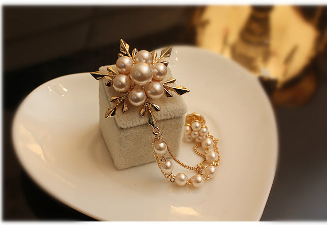 Pearl jewelry set with a ring and bracelet on a white dish
