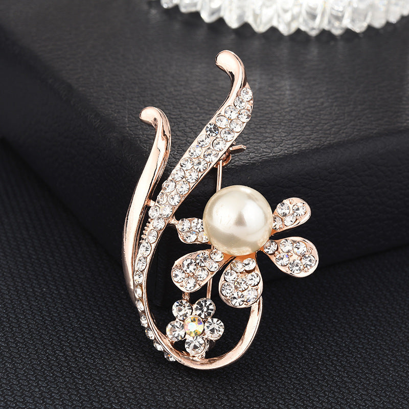 Decorative brooch with pearl and crystals on a black background