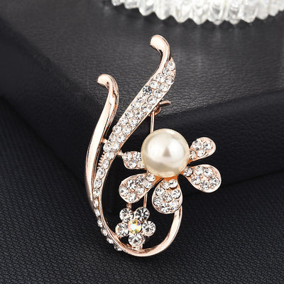 Decorative brooch with pearl and crystals on a black background