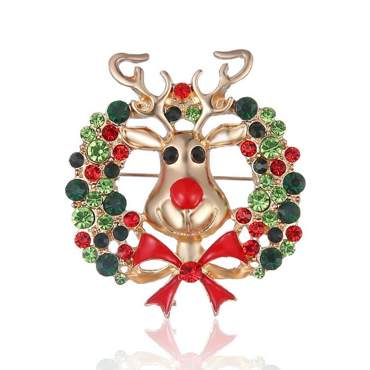 Decorative brooch with a reindeer design and gemstones on a white background