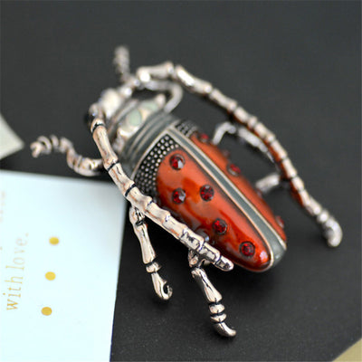 Decorative beetle with red and silver design on a black background