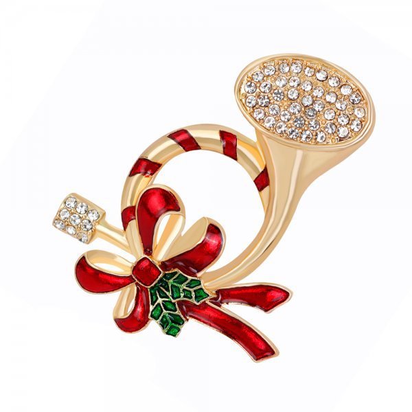 Gold brooch with red bow and green gemstones on a white background