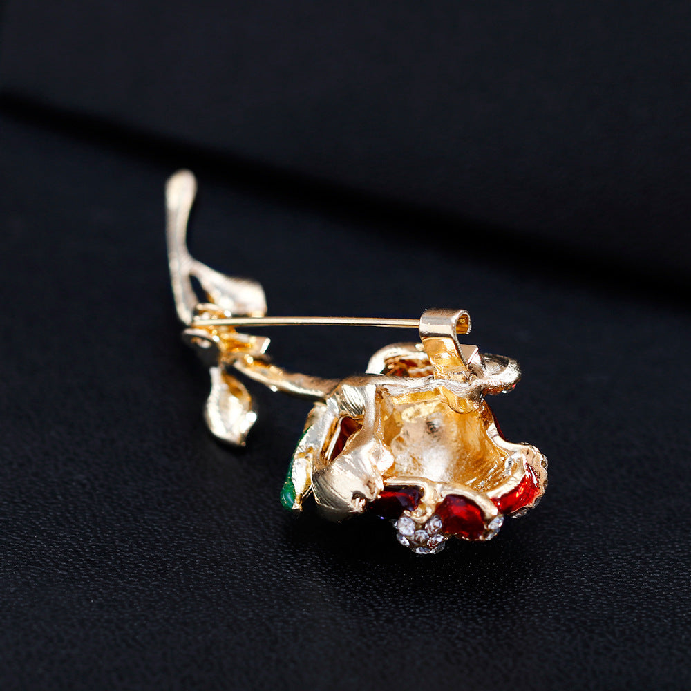the back of a Red rose brooch with gemstones on a black background
