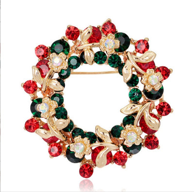 Decorative brooch with red, green, and gold colors on a white background