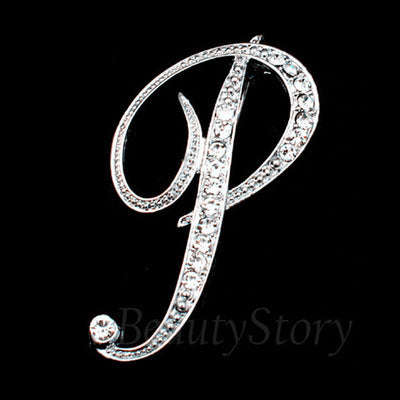 Silver brooch with letter 'P' design on a black background