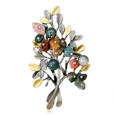 Multicolored gemstone brooch with silver leaves on a white background