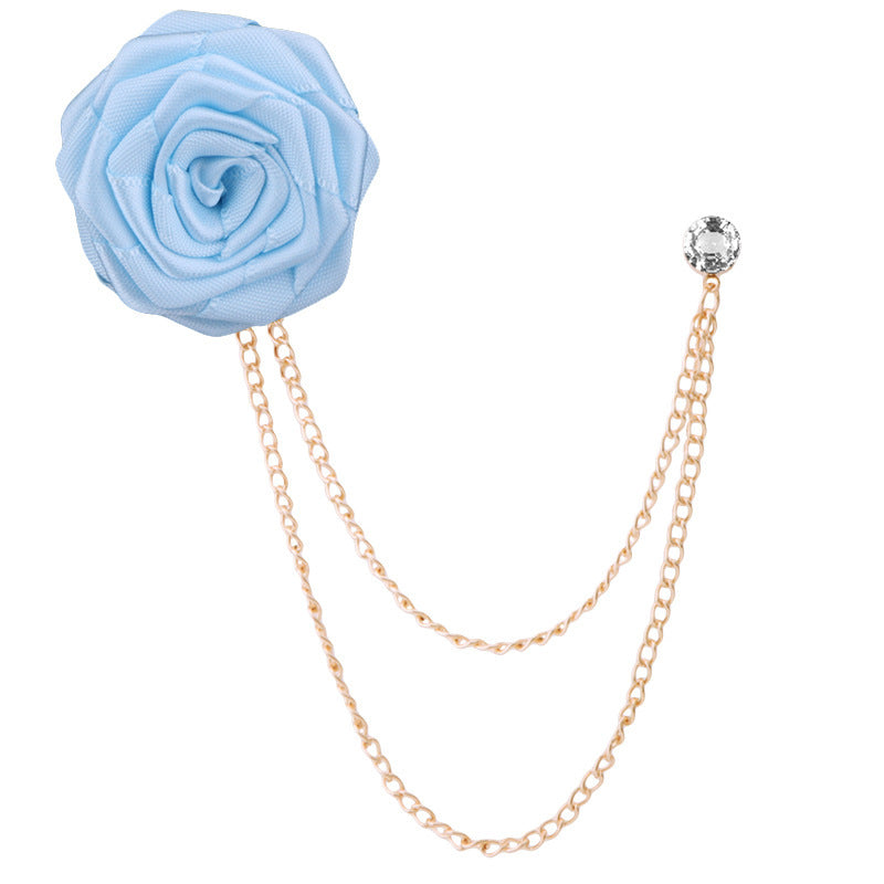 Light blue flower brooch with gold chain on a white background