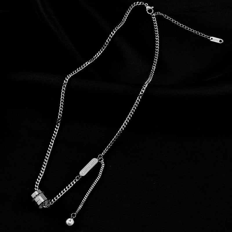 Silver chain necklace with a small pendant on a black background