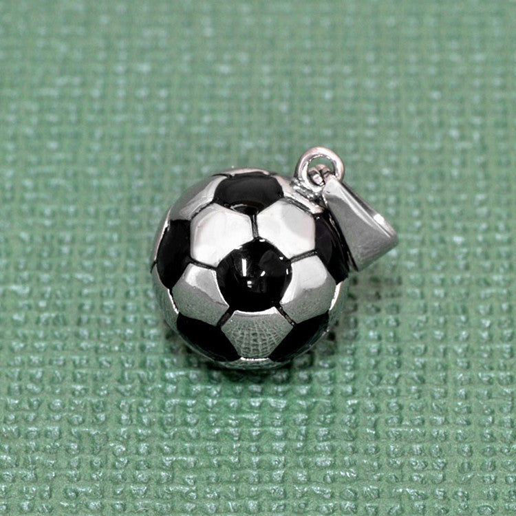 Soccer ball charm on a textured green background