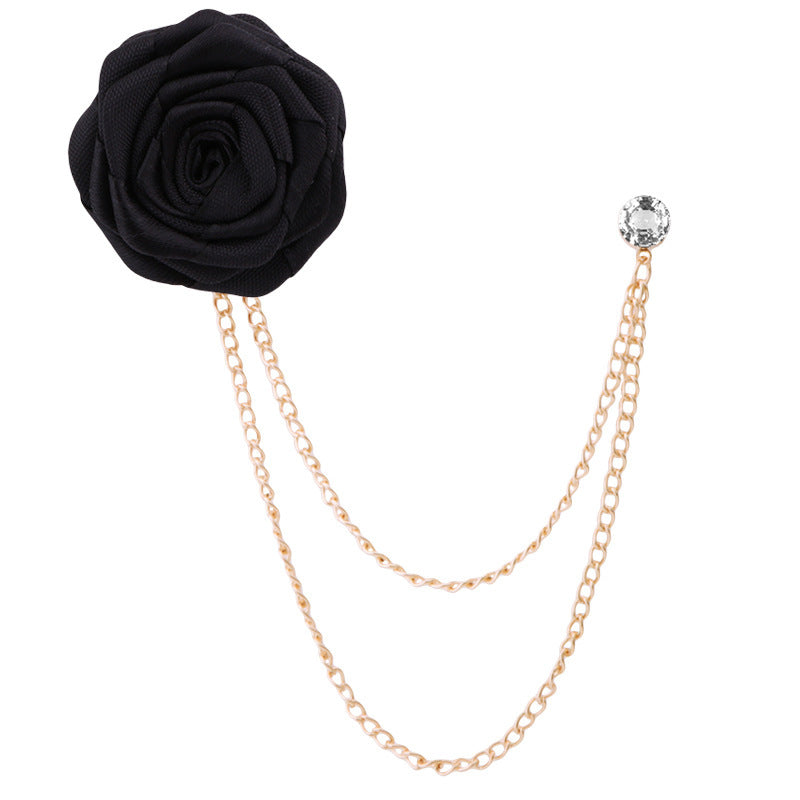 Black rose flower brooch with gold chain and crystal on a white background