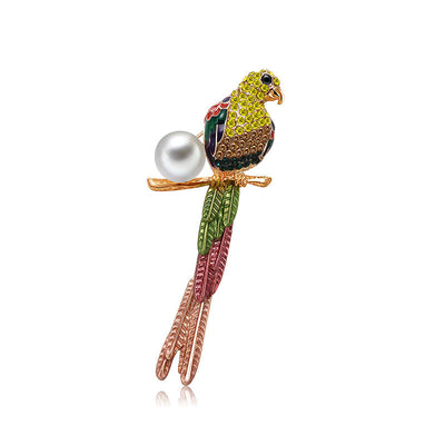 Colorful parrot-shaped brooch with a pearl on a white background