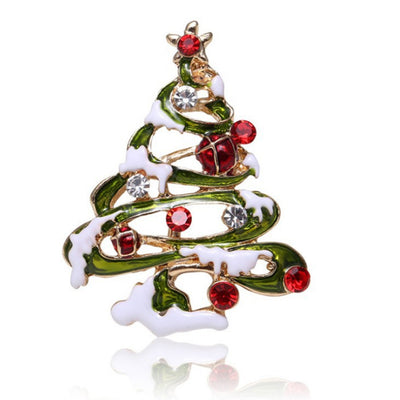 Christmas tree-shaped brooch with red and clear gemstones on a white background