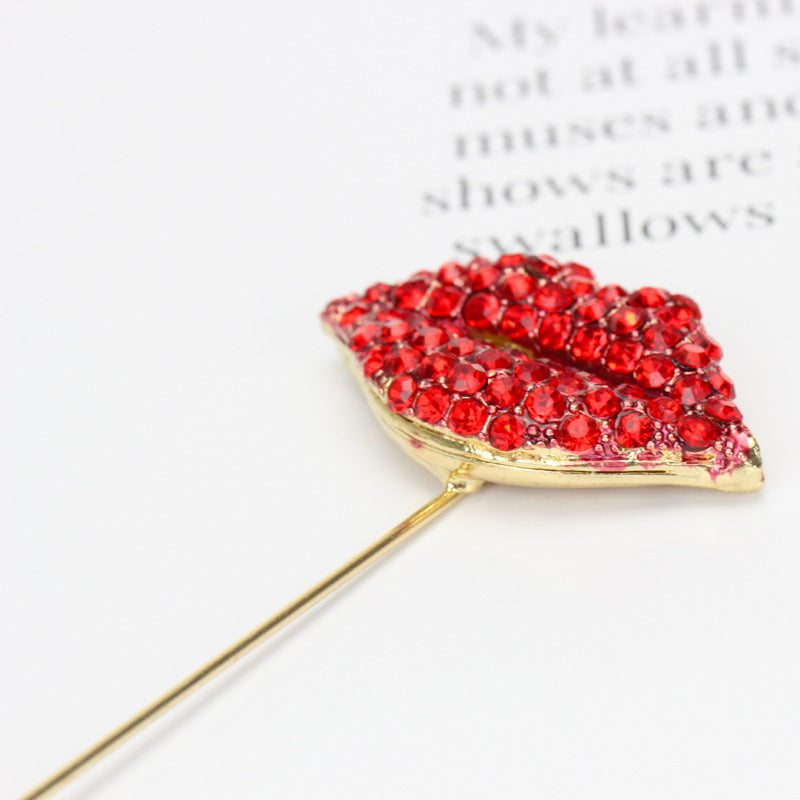 Brooch with red gemstones shaped like lips on a white background
