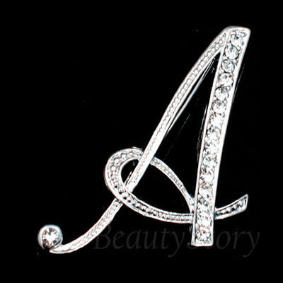 Silver brooch with letter 'A' design on a black background
