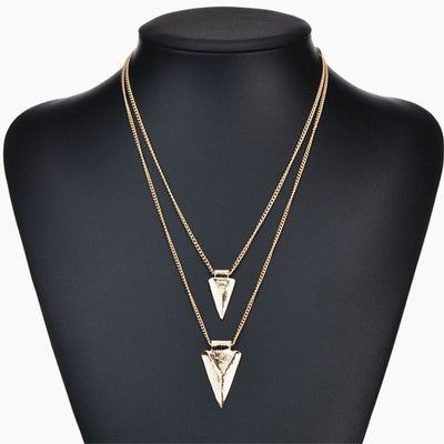 Gold necklace with triangular pendants on a black mannequin bust.