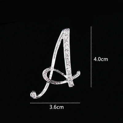 Silver brooch shaped like the letter 'A' with measurements on a black background