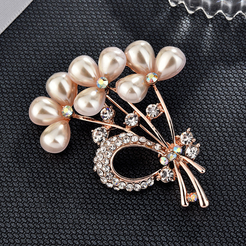 Pearl and crystal brooch on a textured black surface