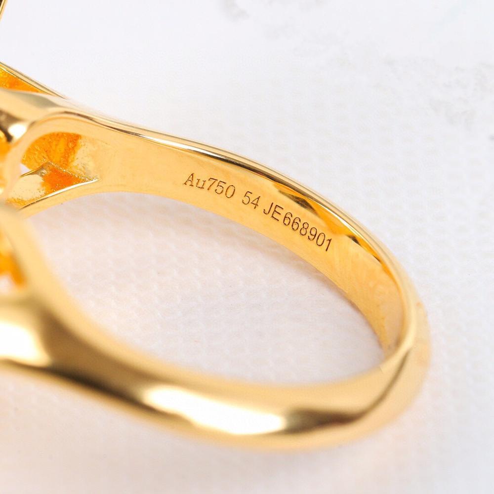 Close-up of a gold ring with visible hallmarking on a white background