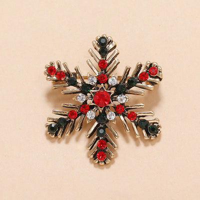 Decorative snowflake Christmas brooch with red and black gemstones on a beige background