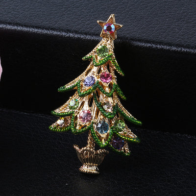 Decorative Christmas tree brooch with gemstones on a black background