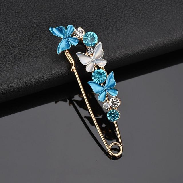 Decorative brooch with blue and white butterflies on a black background