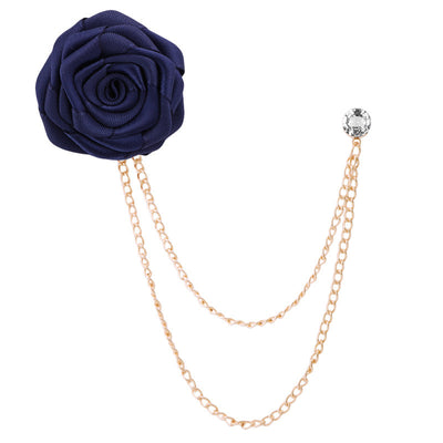 Navy blue rose brooch with gold chain on a white background