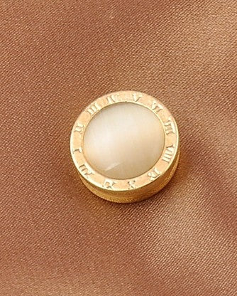 Round roman numbers brooch with gold border on a beige background