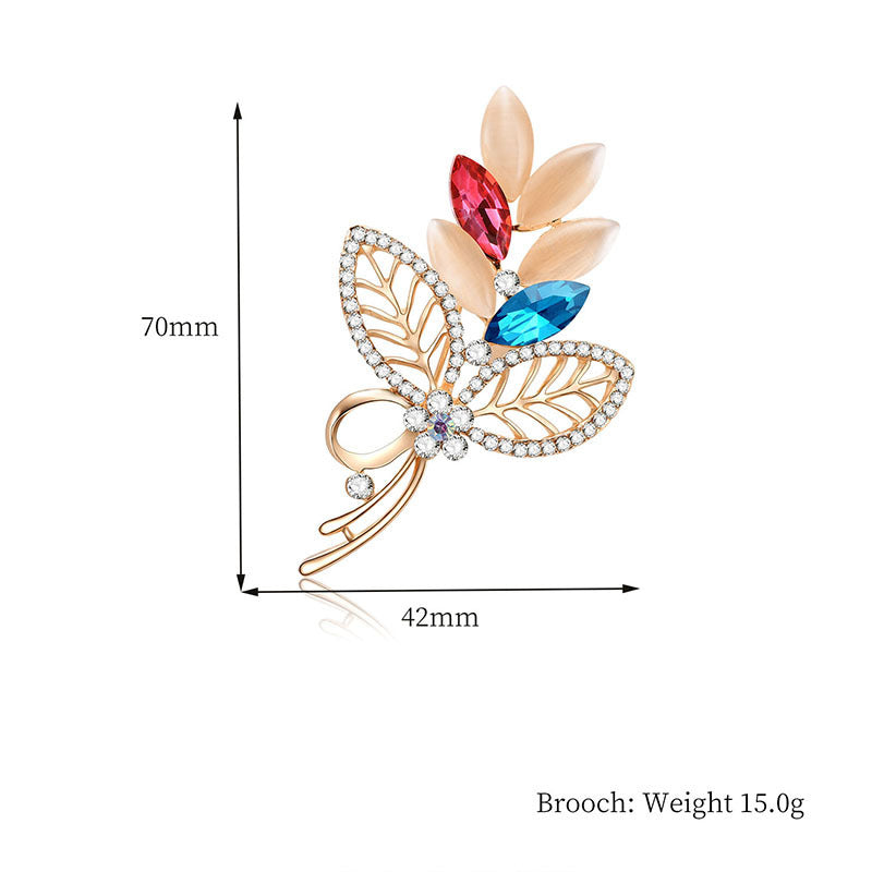 Decorative brooch with colorful gemstones and dimensions on a white background