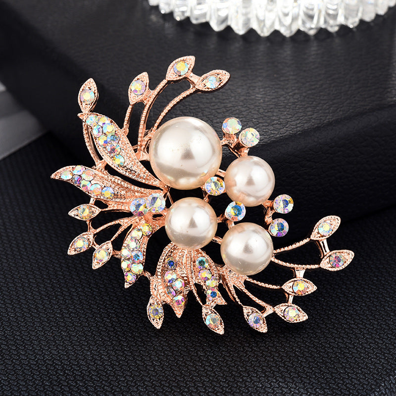 Decorative brooch with pearls and gemstones on a black background