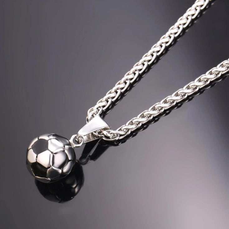Silver necklace with a soccer ball pendant on a dark background