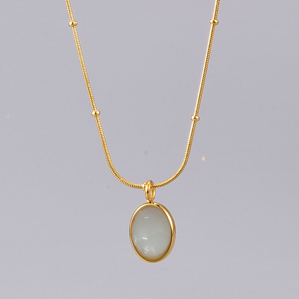 Gold necklace with a pendant on a gray background