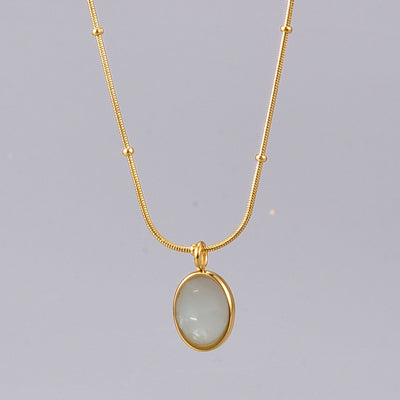 Gold necklace with a pendant on a gray background