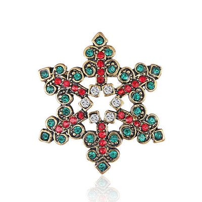 Decorative brooch with gold frame and multicolored gemstones on a white background