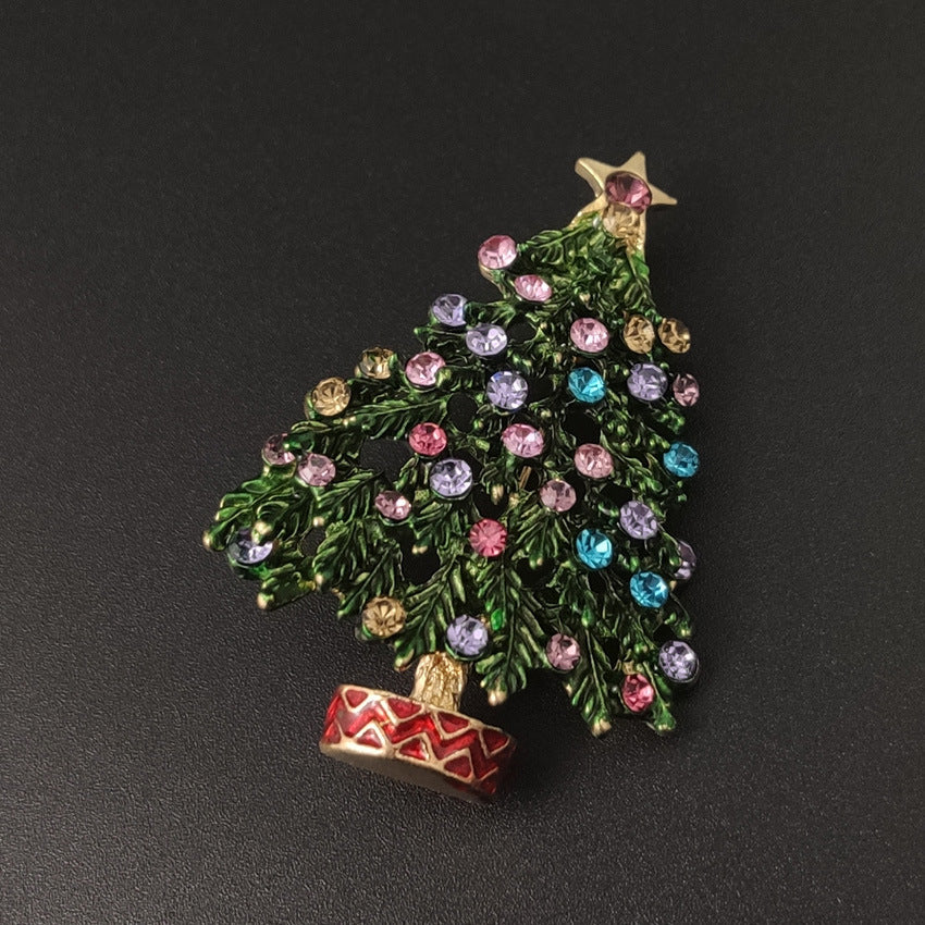 Decorative Christmas tree brooch with colorful gemstones and a star on a dark background