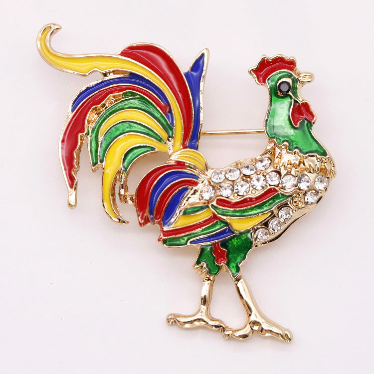 Colorful rooster-shaped brooch with rhinestones on a white background