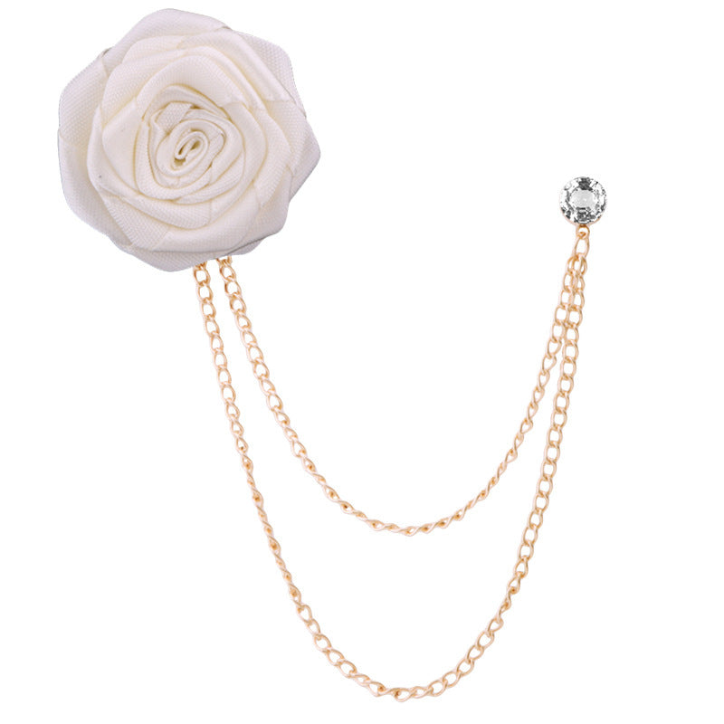 White flower brooch with gold chain on a white background