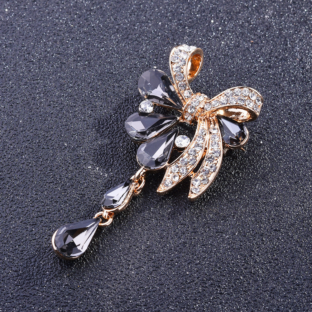 Decorative brooch with gemstones and gold accents on a dark textured background