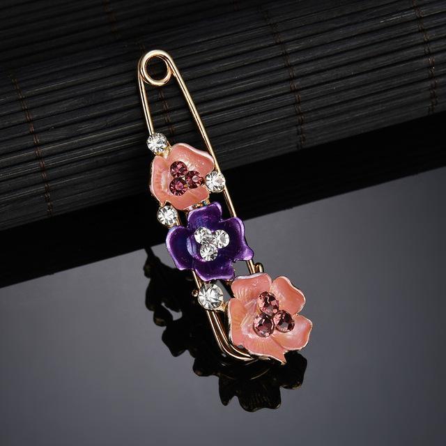Decorative brooch with floral design on a reflective surface