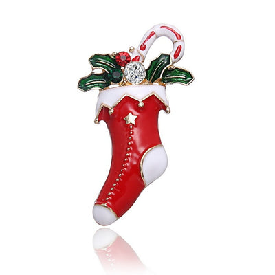 Christmas-themed brooch with red stocking, candy cane, and holly leaves on a white background