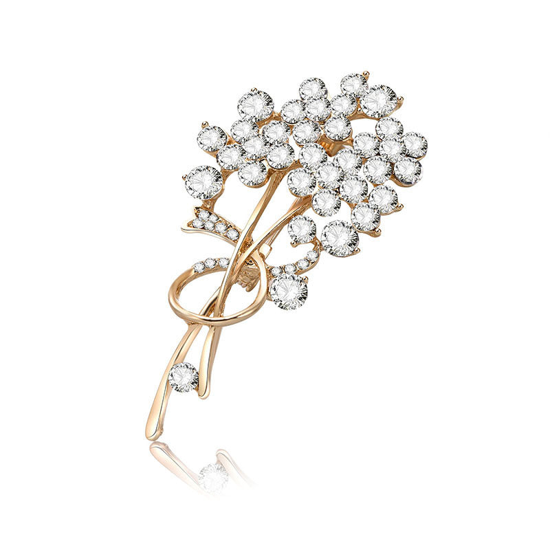Gold brooch with crystal flowers on a white background