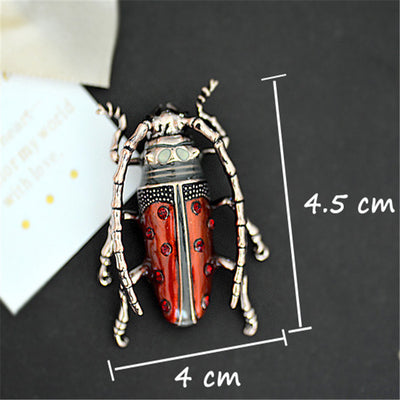 Decorative beetle pendant with measurements on a dark background