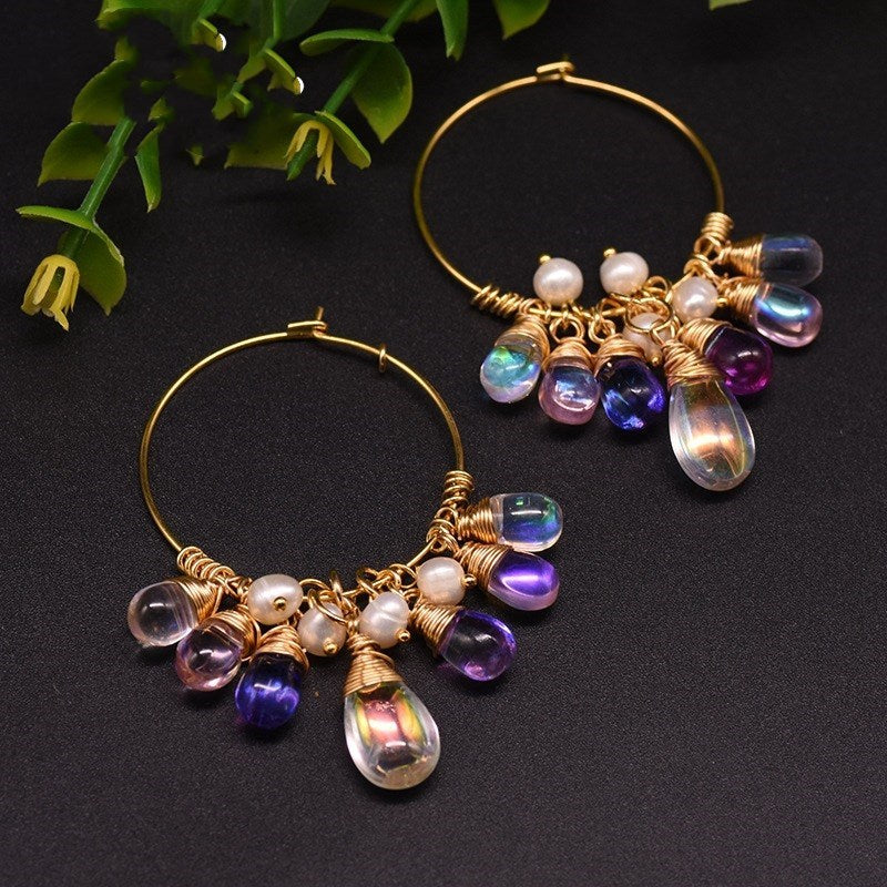 Gold hoop earrings with colorful beads on a dark background