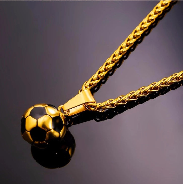 Gold soccer ball pendant on a chain against a dark background