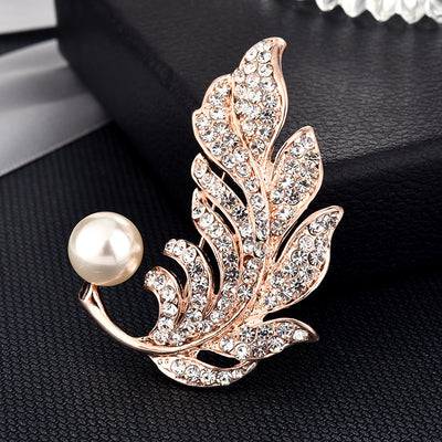 Decorative brooch with pearl and leaf design on a black background