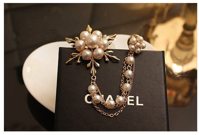 Pearl brooch on a Chanel card with a blurred background