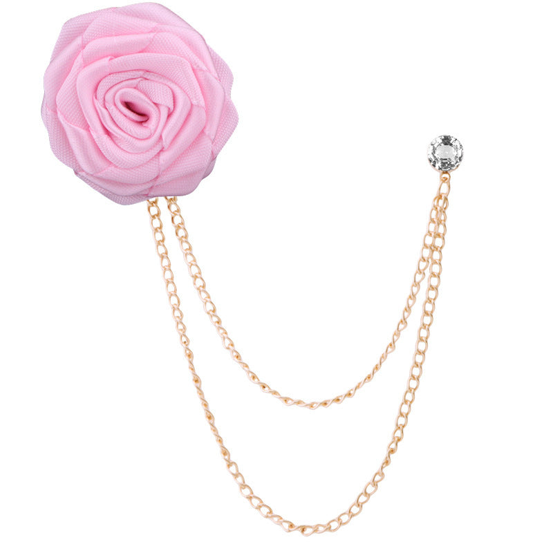 Pink flower brooch with gold chain on a white background