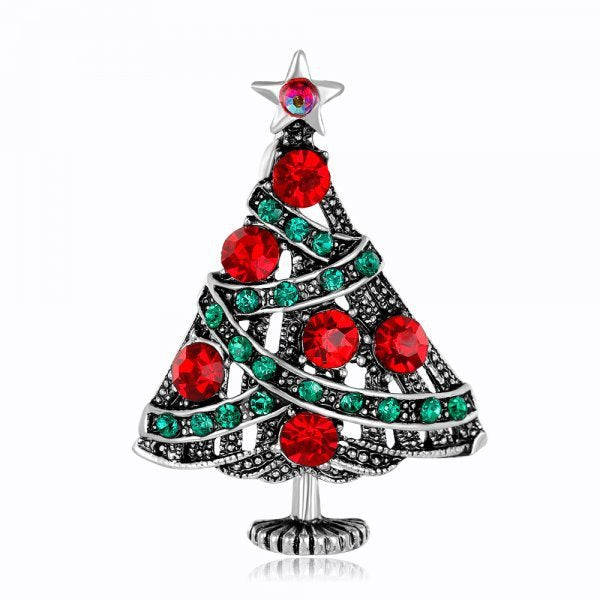 Christmas tree-shaped brooch with red and green gemstones on a white background