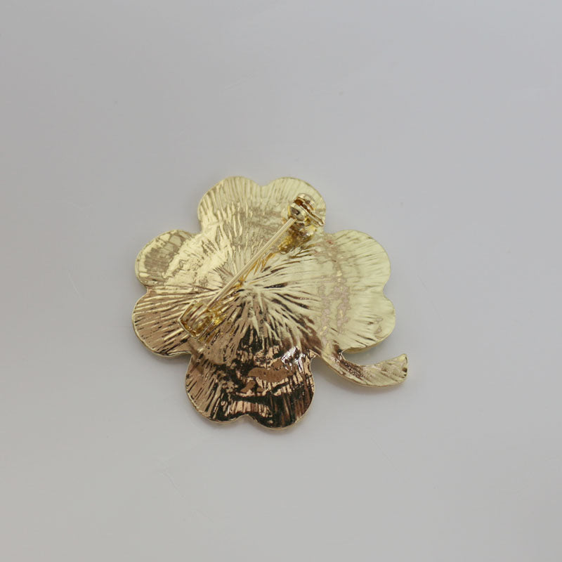 back side of the four-leaf clover brooch on a gray background