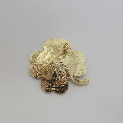 back side of the four-leaf clover brooch on a gray background