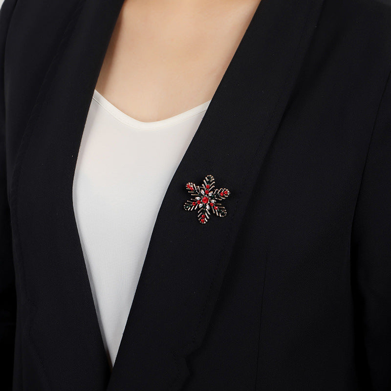 Black blazer with a decorative brooch on a plain background